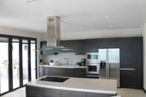 a kitchen with stainless steel appliances and a white counter top at Tamarind Hills Resort & Villas in Johnsons Point