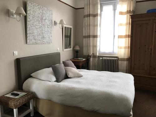 a bedroom with a bed with white sheets and a window at Logis Hôtel & Restaurant "Au Gré du Vent" in Berck-sur-Mer