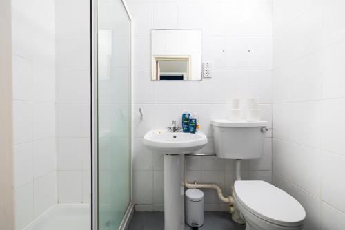 倫敦的住宿－Large Studio on Finchley Road 10，白色的浴室设有卫生间和水槽。
