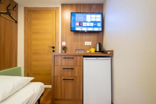 een kamer met een bed en een tv aan de muur bij İstanbulites Hotel in Istanbul