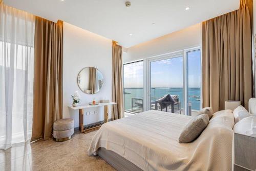 1 dormitorio con 1 cama grande y vistas al océano en Private Beach - 4BR - 8 Sleep - Pool - 180 grades Sea & Ain View - Huge Balcony - Parking - Prime Location, en Dubái