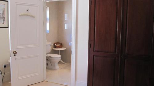 a bathroom with a toilet and a wooden door at Dromard in Kenmare
