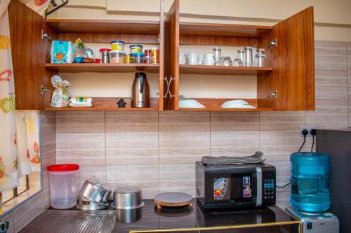 a kitchen with a counter with a toaster and a microwave at Partline Apartment in Kisii