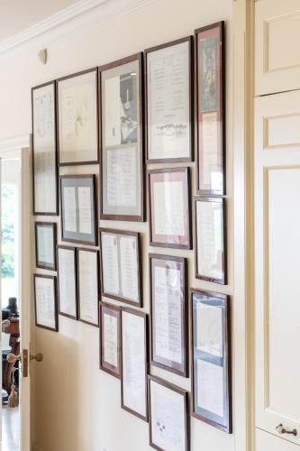 a wall of framed papers on a wall at Dromard in Kenmare