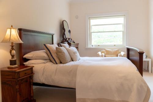 a bedroom with a bed with a lamp and a window at Dromard in Kenmare