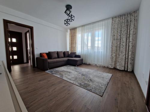 a living room with a couch and a large window at Downtown Apartment in Râmnicu Vâlcea