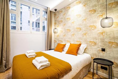 una camera da letto con un letto e asciugamani di 191 Suite Auteuil - Superb apartment in Paris a Parigi