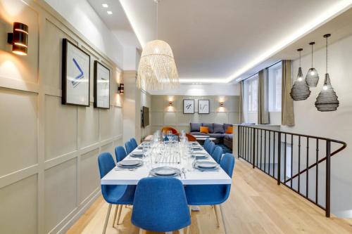 una sala da pranzo con un lungo tavolo e sedie blu di 191 Suite Auteuil - Superb apartment in Paris a Parigi