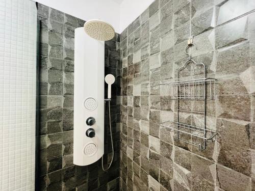 um chuveiro na casa de banho com uma parede em azulejo em Terraza del sol em Candelaria