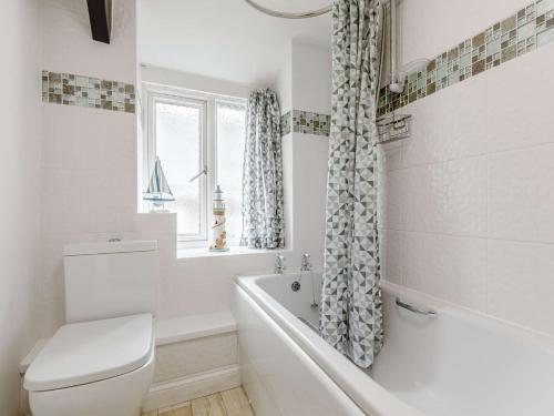 uma casa de banho com um WC, uma banheira e uma janela. em 3 Bed in Hartland 88143 em Hartland