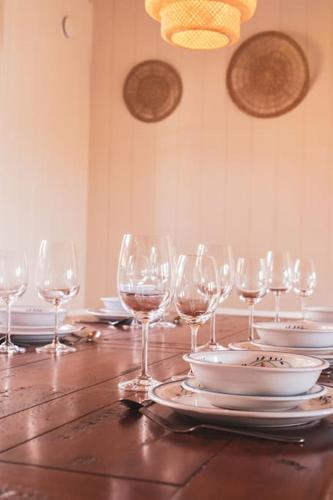 a wooden table with wine glasses and plates on it at Långrösta; Ruime blokhut grenzend aan bos in Hagfors