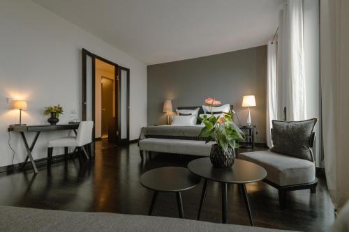 a living room with a bed and a couch and a table at A-ROSA Hotel Ceres am Meer - Adults Only in Binz