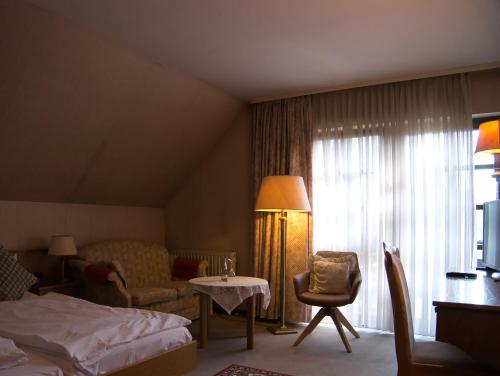 een hotelkamer met een bed, een tafel en een stoel bij Hotel Tannenhof in Gonterskirchen
