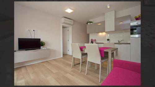 cocina y sala de estar con mesa y sillas en Adria Apartments, en Poreč