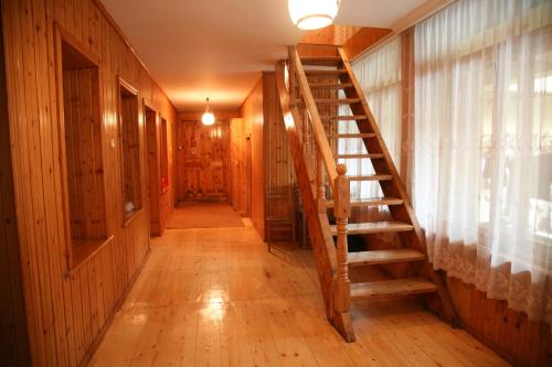 a hallway with a wooden staircase in a house at Eka&Nino GuestHouse in Mestia