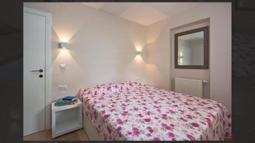 1 dormitorio con cama y espejo en la pared en Adria Apartments, en Poreč
