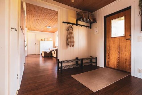 a hallway with a wooden door and a living room at Långrösta; Ruime blokhut grenzend aan bos in Hagfors