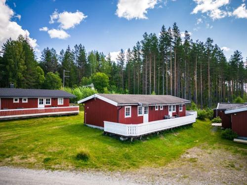 a couple of red cabins in a field with trees at Långrösta; Ruime blokhut grenzend aan bos in Hagfors