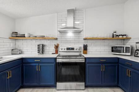 cocina con armarios azules y fogones en Starlight Horizon 4 Cabins EFGH - 4 Side-by-Side Cabins Pet-Friendly Texas Hill Country Group Stay Near Canyon Lake - Pool, Stargazing, Sleeps 32, en Canyon Lake