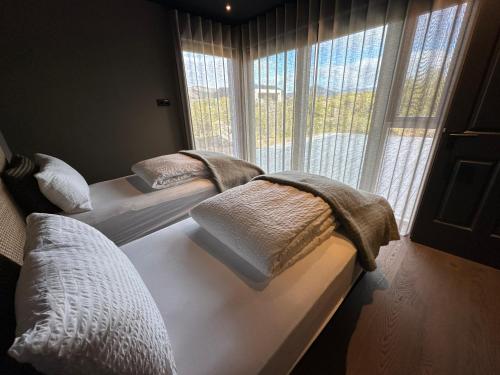 2 camas en una habitación con ventana en Stunning Luxury Chalet in West Iceland en Reykholt