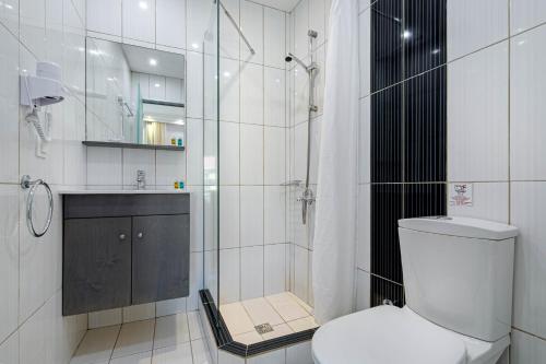 a white bathroom with a shower and a toilet at Palotel Design Gouvia in Gouvia