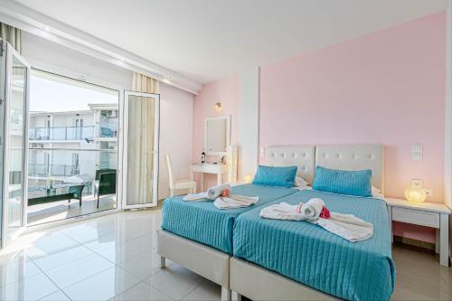 een slaapkamer met een bed met handdoeken erop bij Palotel Design Gouvia in Gouvia