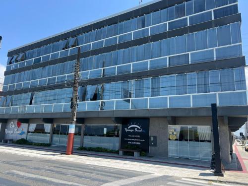 a building with a palm tree in front of it at Navega Beach Palace Hotel in Navegantes