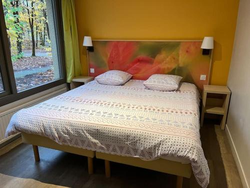 een slaapkamer met een bed met een schilderij aan de muur bij Cottage-8p-Les Hauts de Bruyères-225 in Chaumont-sur-Tharonne
