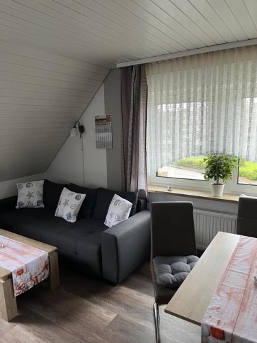 Una sala de estar con un sofá y una ventana. en Haus-Sonneck, en Esens