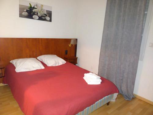 a bedroom with a bed with a red blanket at Le Castel d'olmes in Laroque-dʼOlmes