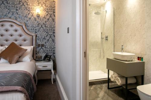 a bedroom with a bed and a sink and a shower at WA Hotel (Wroxall Abbey) in Wroxall