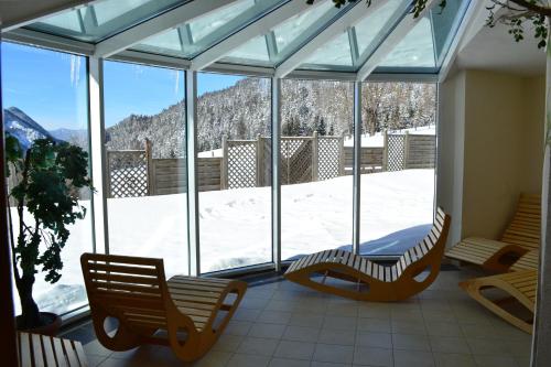 a screened in porch with a view of a snow covered mountain at Premium Wanderhotel Steirerhof in Schladming