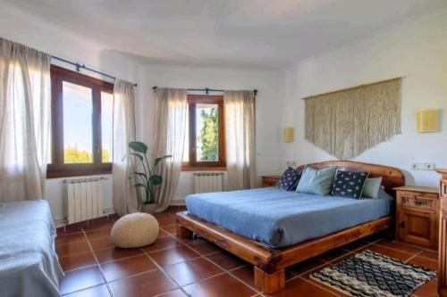 a bedroom with a bed with a blue comforter at Authentic 4BR Pool & Sauna Villa, Sant Agusti in San Antonio Bay