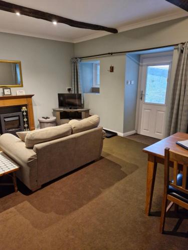 a living room with a couch and a television at Elysian Fields @ Ing Hill Lodge in Outhgill