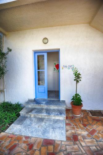 a blue door of a house with a potted plant at Fragiskos Hotel in Matala