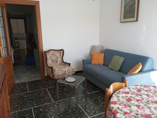 a living room with a blue couch and a chair at Tigullio Vacations - Da Gabriella in Chiavari