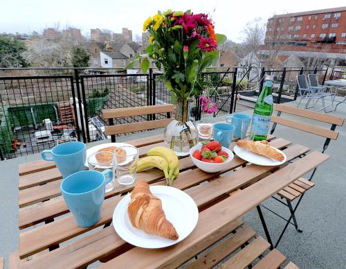 drewniany stół z jedzeniem i napojami na balkonie w obiekcie 2 BED TERRACED FLAT PICCADILLY LINE w Londynie