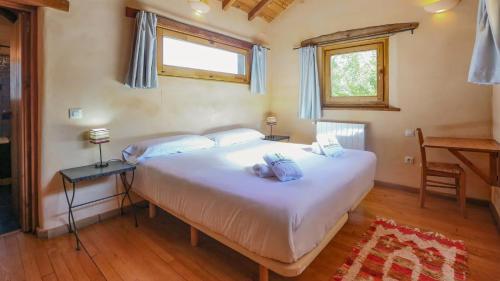- une chambre avec un grand lit blanc et un bureau dans l'établissement Casas Rurales Camino del Castaño, à Galaroza