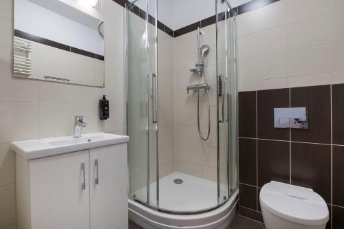a bathroom with a shower and a toilet and a sink at MariSol in Świnoujście