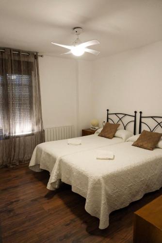 a bedroom with two beds and a ceiling fan at Mas del Cel - Casa Rural in Confrides