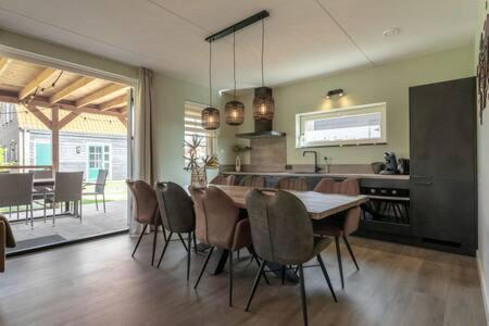 a kitchen and dining room with a table and chairs at Hello Zeeland - vakantiewoning Knuitershoek 86 in Kloosterzande