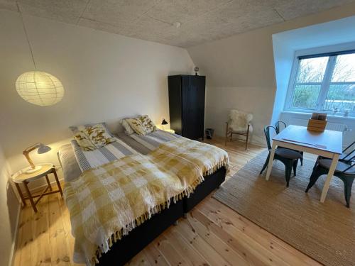 een slaapkamer met een bed, een tafel en een bureau bij Room 17 - Hawkraft kulturhotel in Vestervig