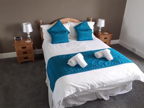 a bedroom with a large bed with blue pillows at Island view in Spittal