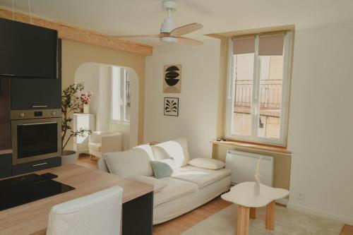 a living room with a white couch and a tv at Au cœur de Hyeres, Idéal pour les couples ! in Hyères