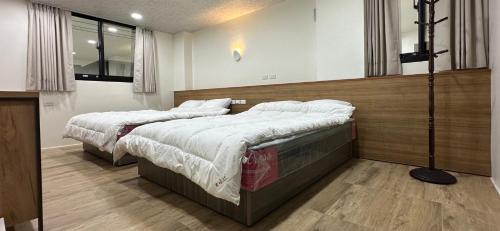 two beds are in a room with at Fulong City B&B in Yilan City