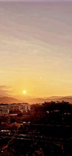 a sunset over a city with the sun in the sky at Fulong City B&B in Yilan City