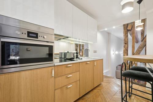 cocina con armarios de madera y horno con fogones en 264 Suite Latino - Superb apartment in Paris, en París