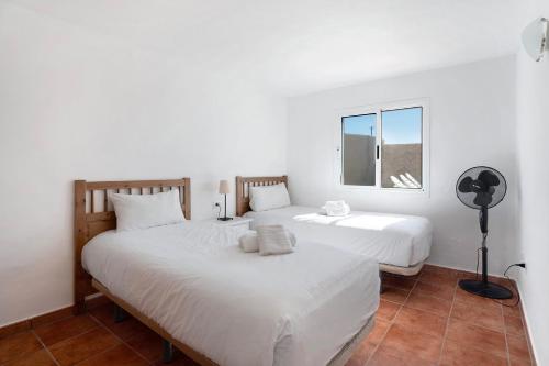 a bedroom with two beds and a window at Los Corcos Rural Farm With Private Pool in Playa de San Juan