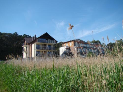 una casa en medio de un campo de hierba alta en Villa Piaski, en Krynica Morska