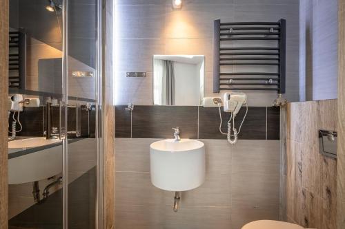 een badkamer met een wastafel en een spiegel bij 70s Business Room in Krakau